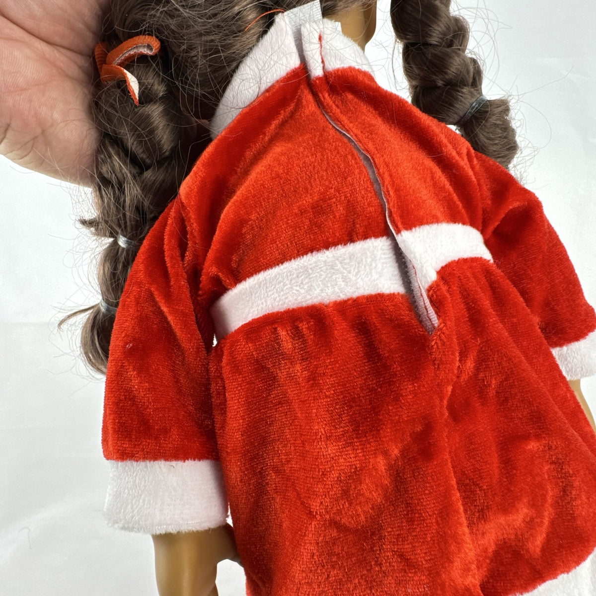 Battat Our Generation 18-inch doll with brown braided pigtails wearing a red and white holiday Santa dress and boots