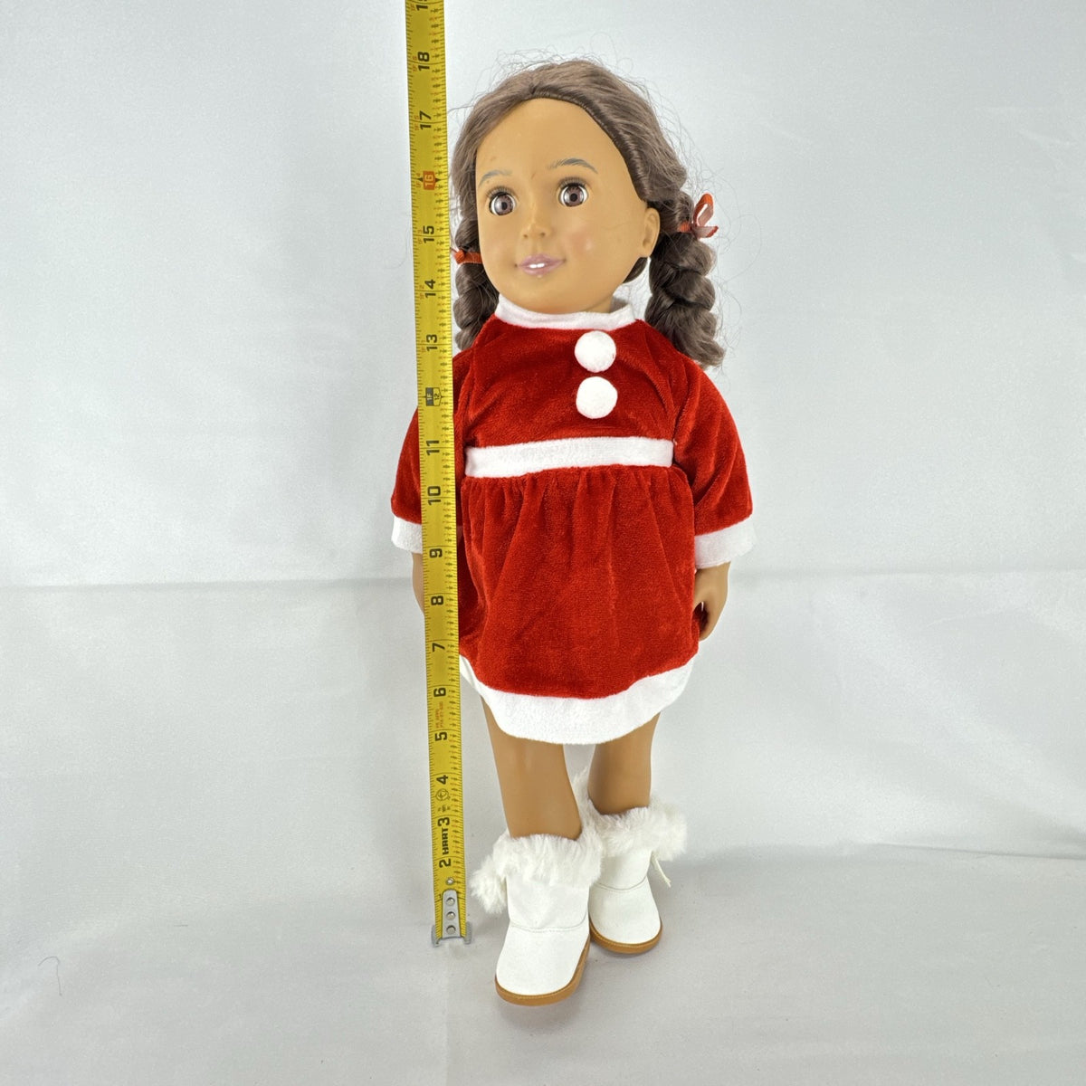Battat Our Generation 18-inch doll with brown braided pigtails wearing a red and white holiday Santa dress and boots