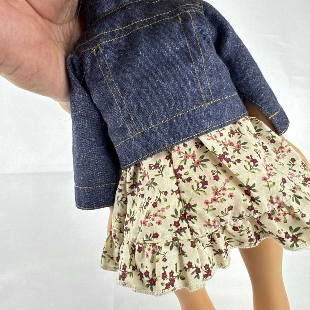 Geoffrey LLC Journey Girls 18-inch doll with blonde rainbow-streaked hair, floral dress, and denim jacket.