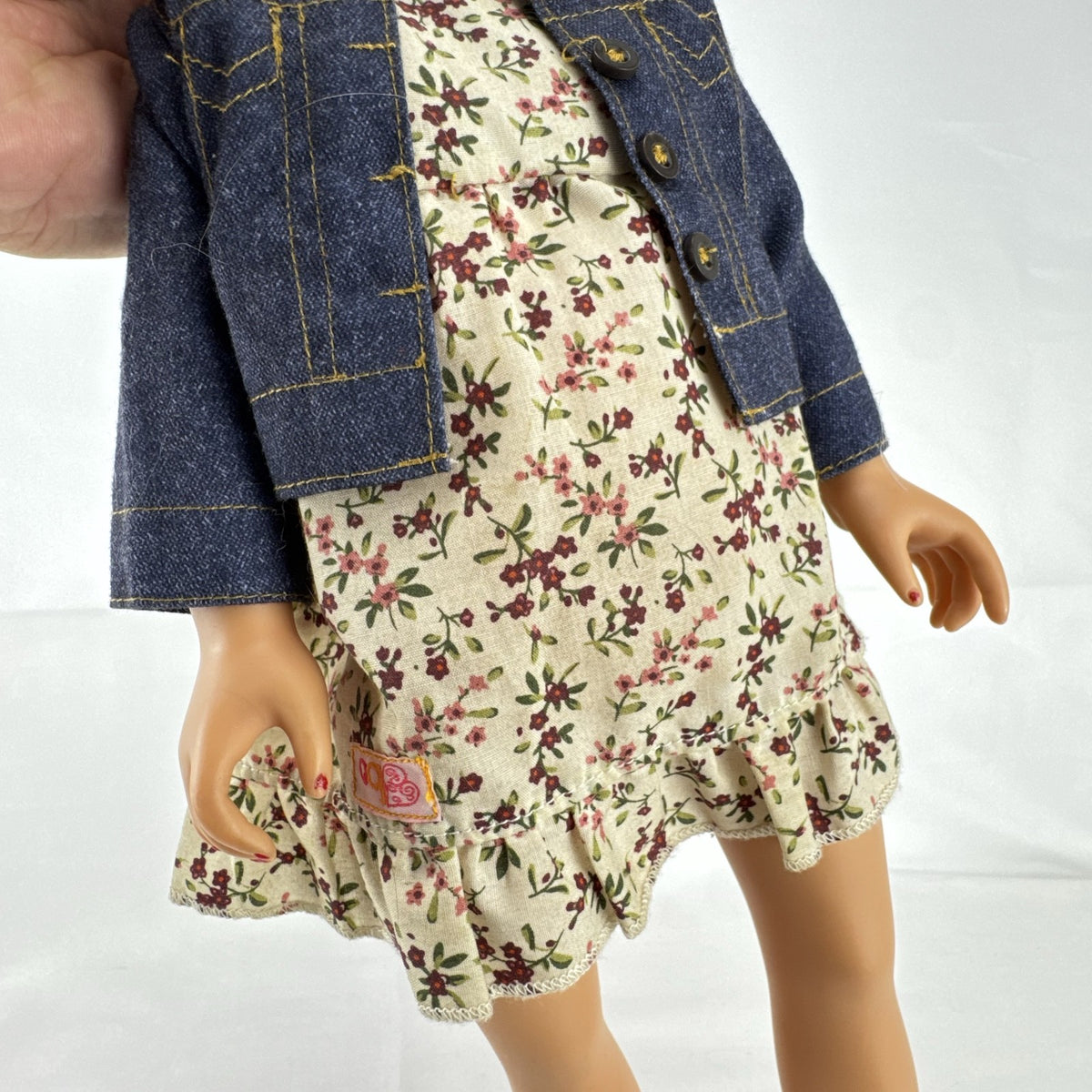 Geoffrey LLC Journey Girls 18-inch doll with blonde rainbow-streaked hair, floral dress, and denim jacket.