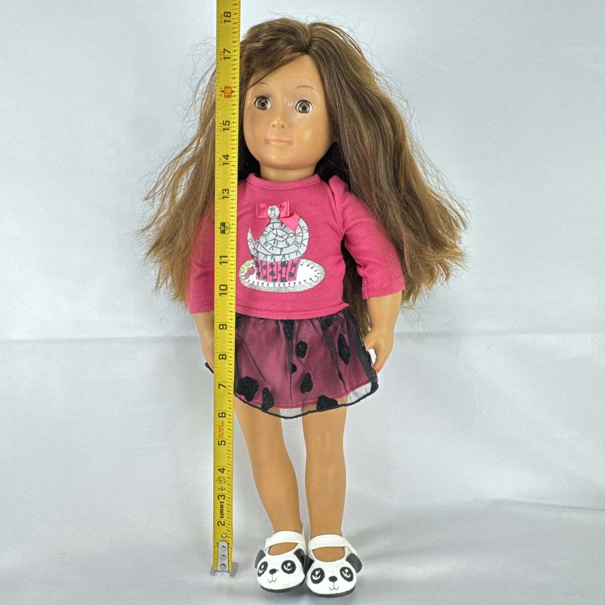 Battat Our Generation 18-inch brunette play doll wearing a pink cupcake shirt, tulle skirt, and panda shoes.