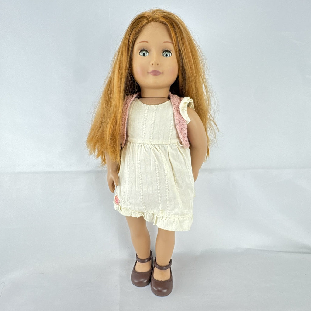 Battat Our Generation 18-inch doll with auburn hair and green eyes wearing cream ruffle dress and pink shrug