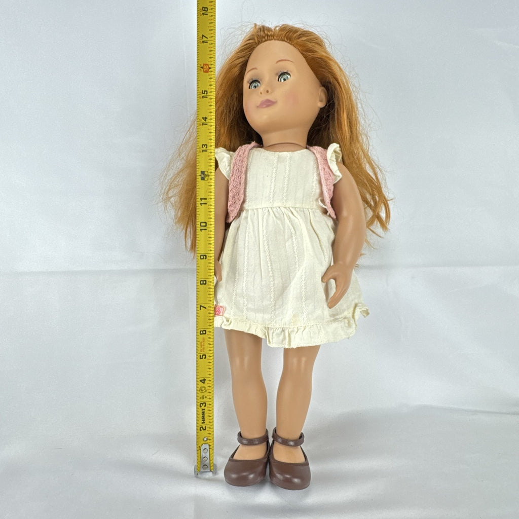 Battat Our Generation 18-inch doll with auburn hair and green eyes wearing cream ruffle dress and pink shrug