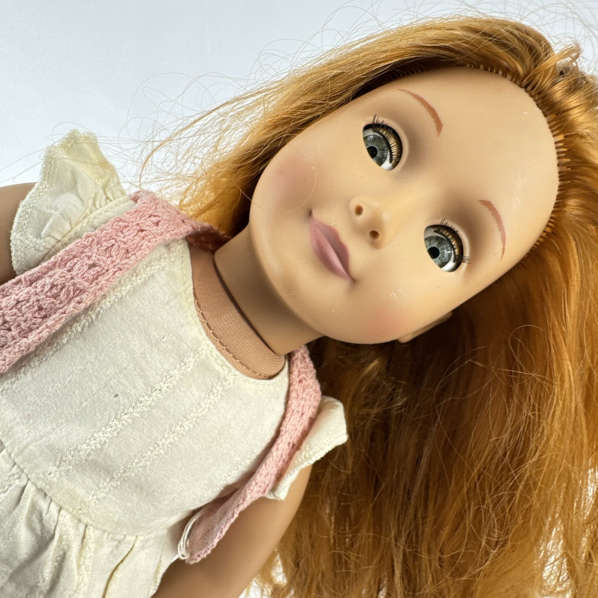 Battat Our Generation 18-inch doll with auburn hair and green eyes wearing cream ruffle dress and pink shrug