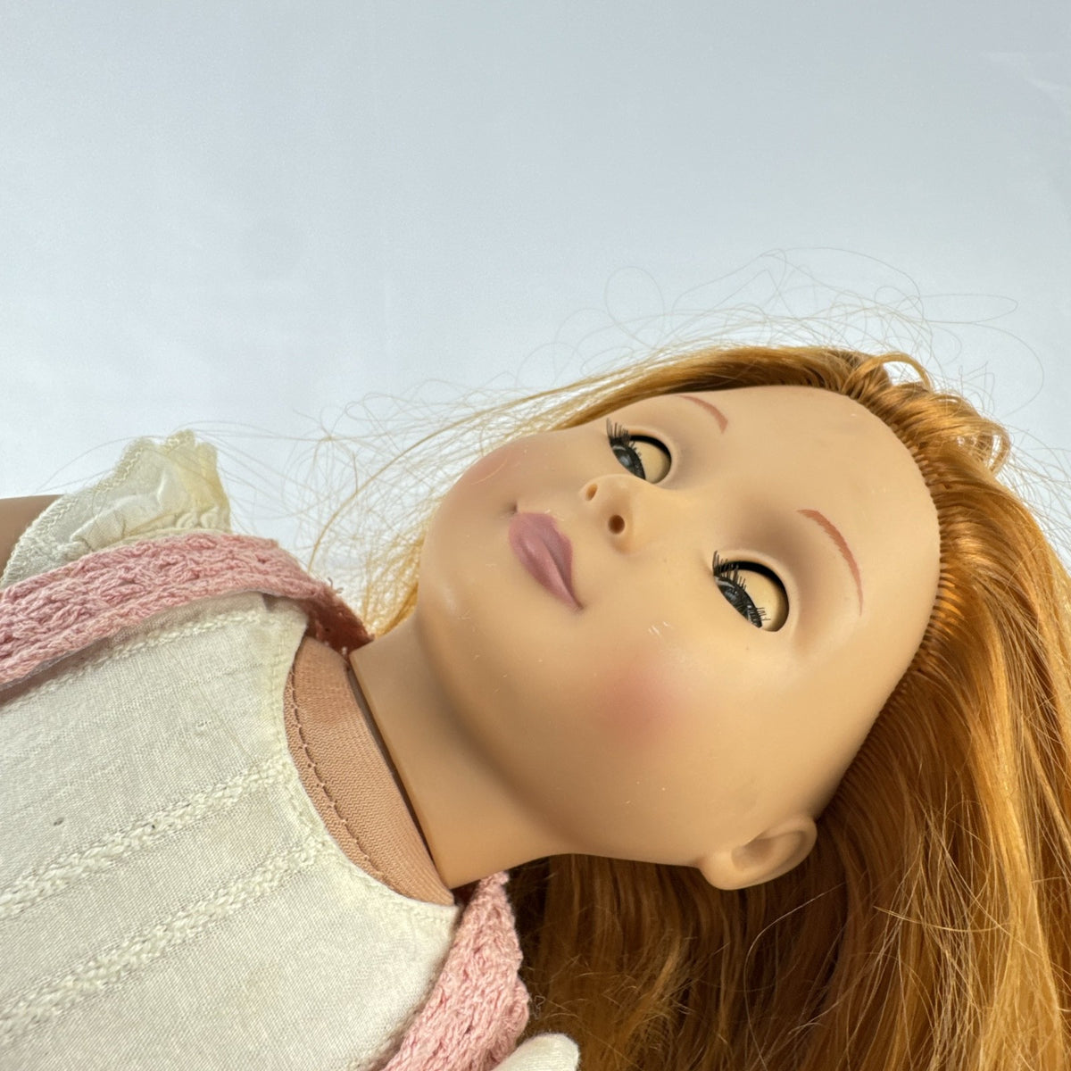 Battat Our Generation 18-inch doll with auburn hair and green eyes wearing cream ruffle dress and pink shrug