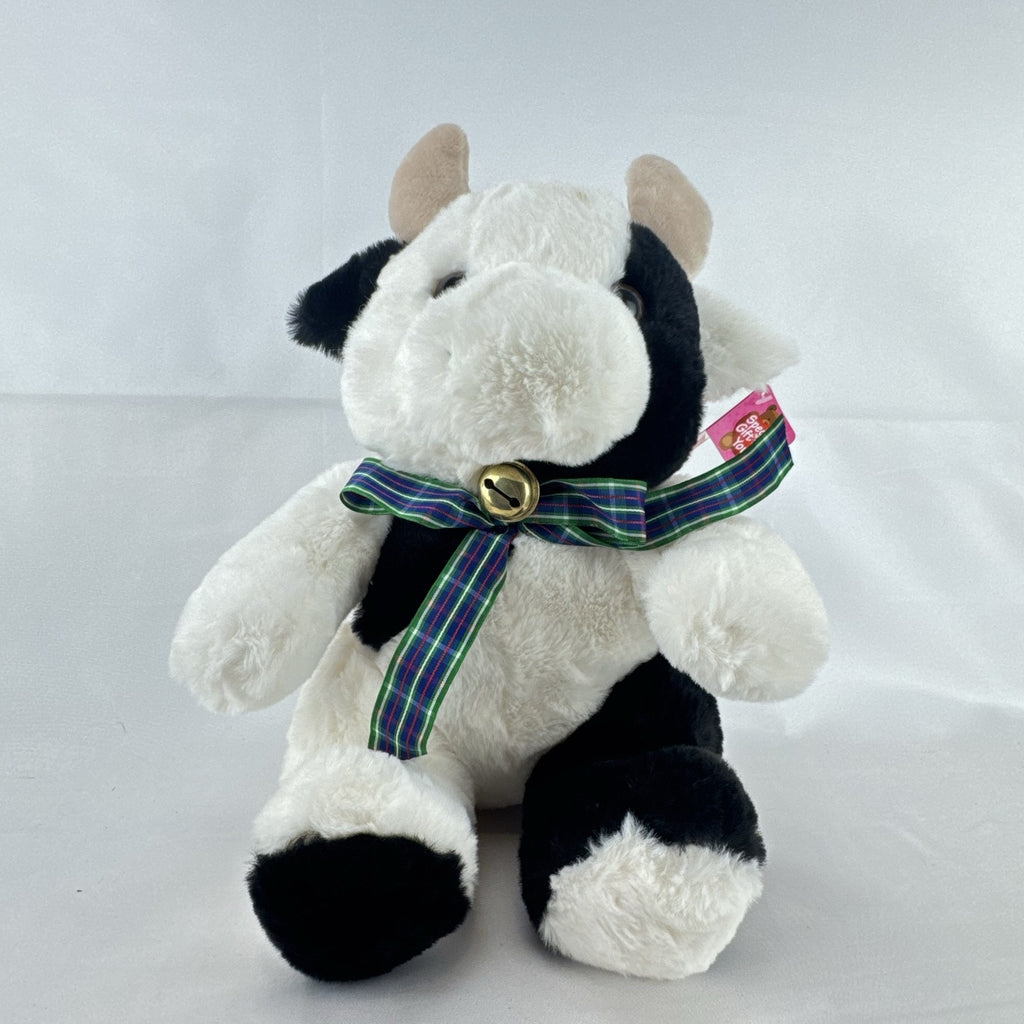 Star Gifts 13-inch black and white Holstein cow plush wearing a green plaid ribbon and jingle bell