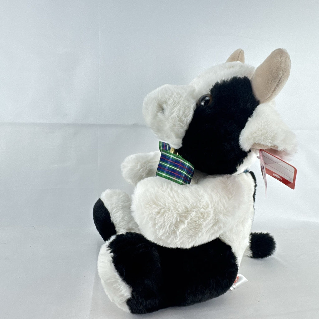 Star Gifts 13-inch black and white Holstein cow plush wearing a green plaid ribbon and jingle bell
