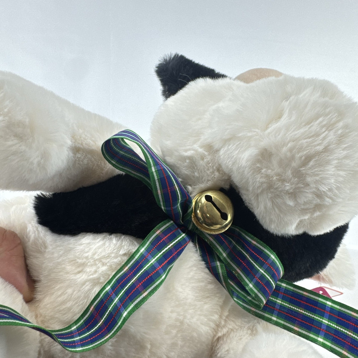 Star Gifts 13-inch black and white Holstein cow plush wearing a green plaid ribbon and jingle bell