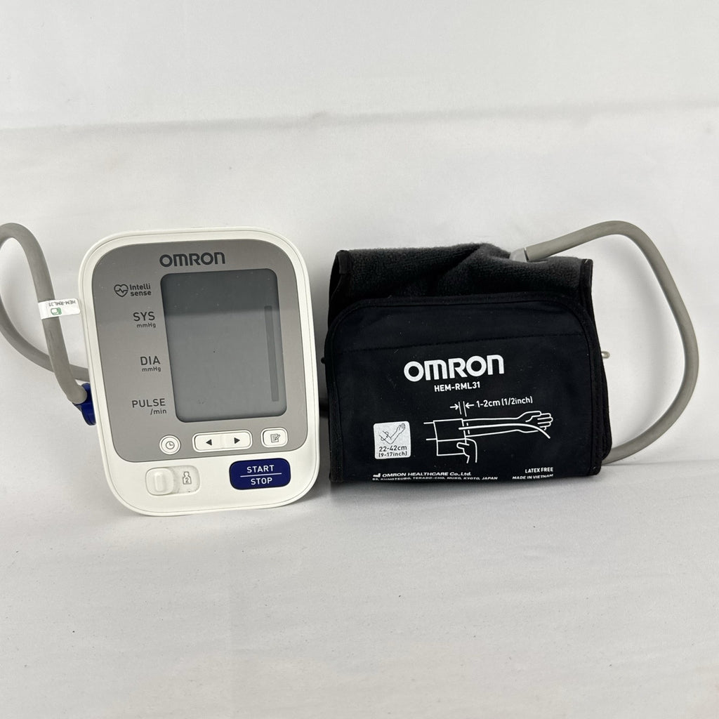 White Omron upper arm blood pressure monitor with digital LCD display and adjustable wide fabric cuff
