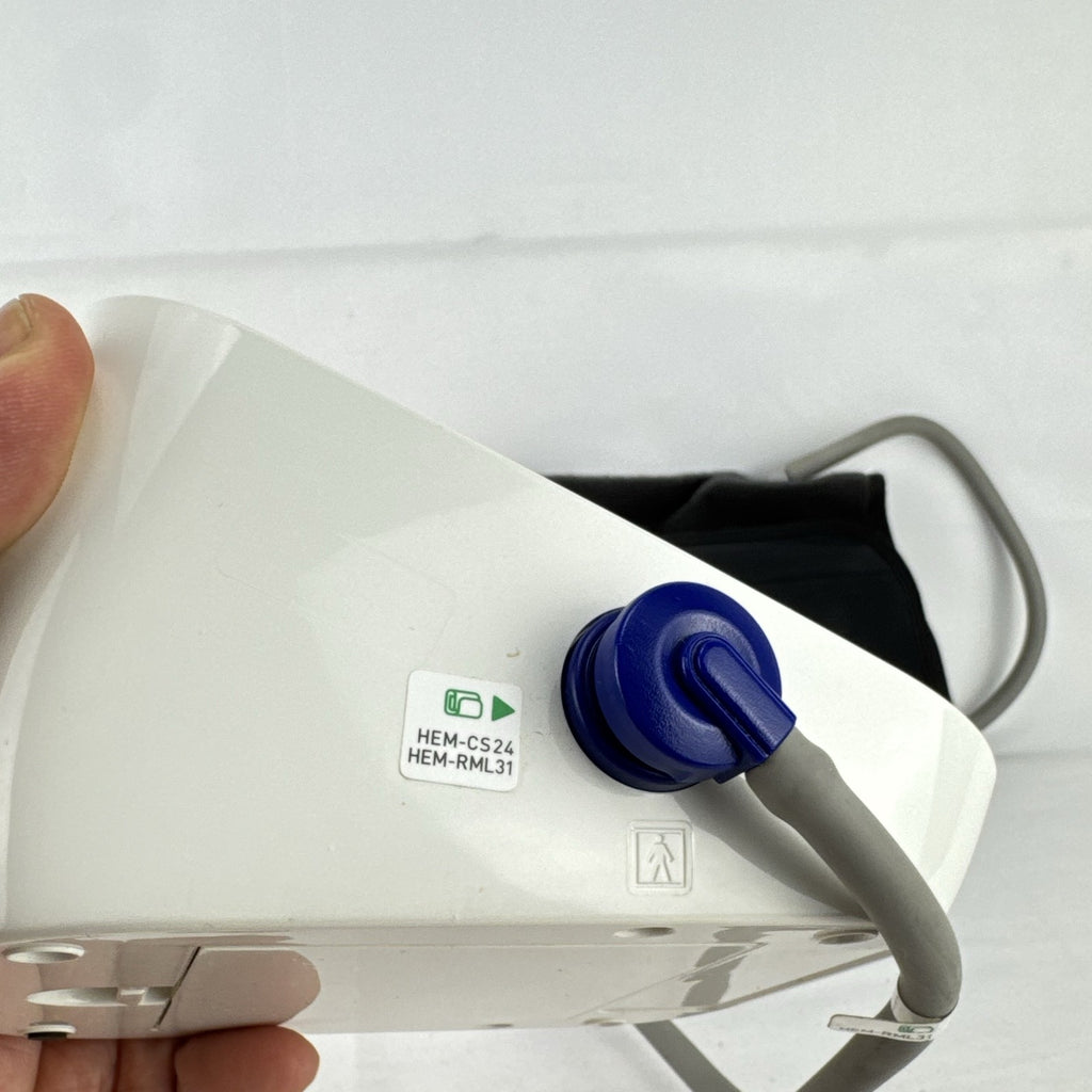 White Omron upper arm blood pressure monitor with digital LCD display and adjustable wide fabric cuff