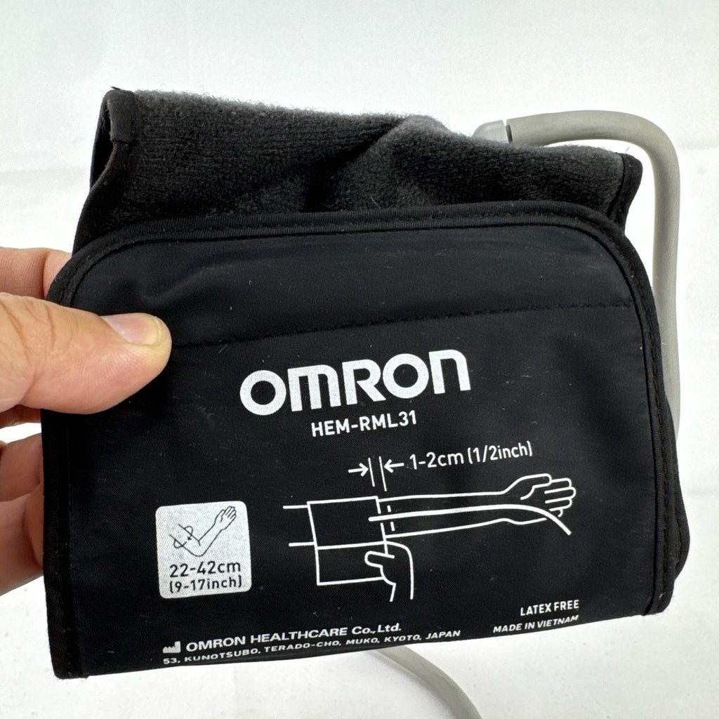 White Omron upper arm blood pressure monitor with digital LCD display and adjustable wide fabric cuff