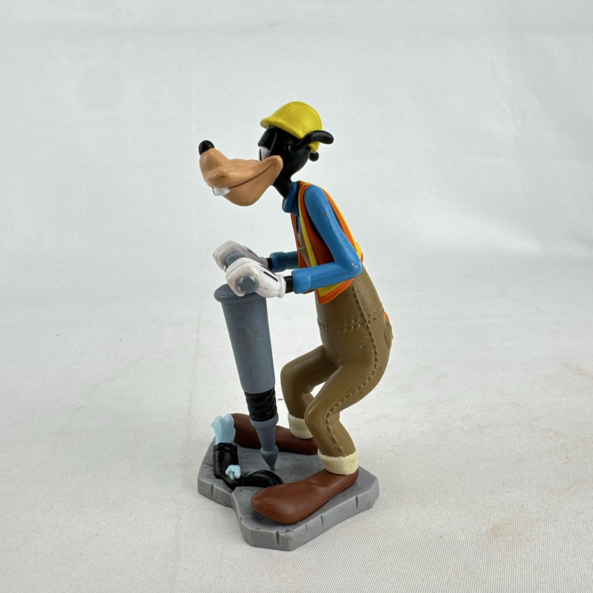 Disney Goofy construction worker PVC figurine holding a jackhammer and wearing a hard hat