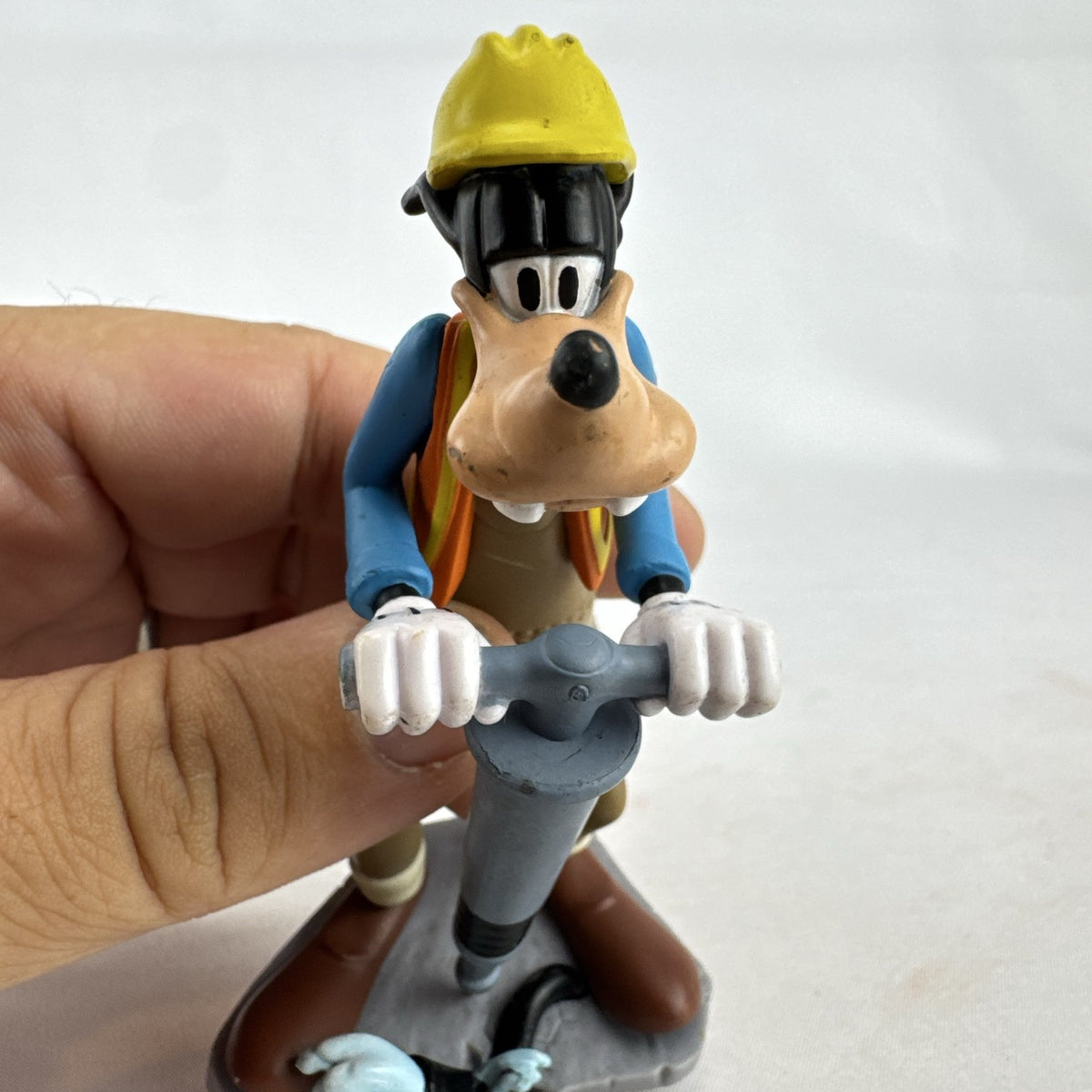 Disney Goofy construction worker PVC figurine holding a jackhammer and wearing a hard hat