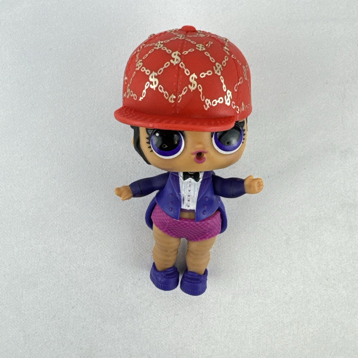 MGA Entertainment L.O.L. Surprise! 3-inch vinyl doll wearing a purple tuxedo suit and red cap