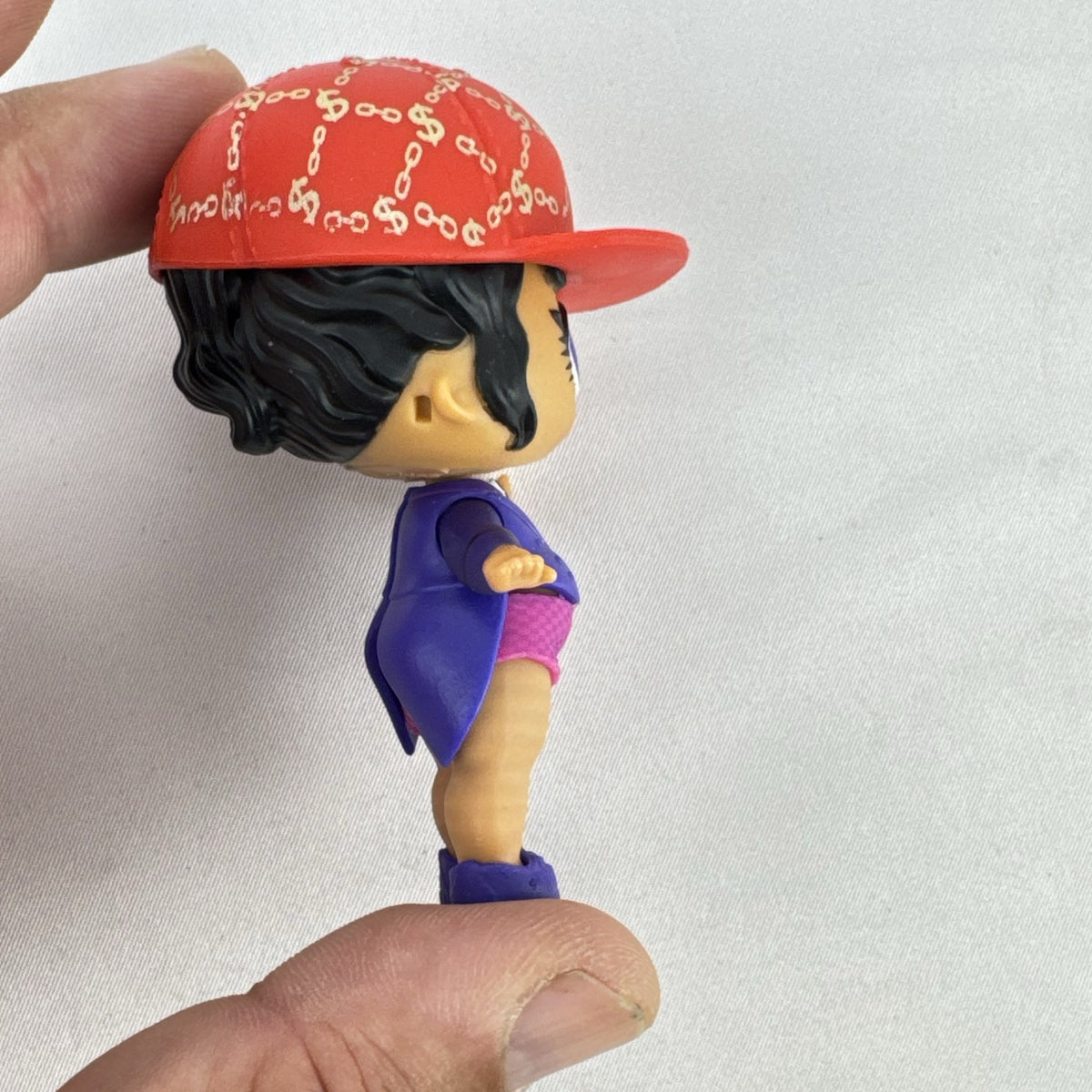 MGA Entertainment L.O.L. Surprise! 3-inch vinyl doll wearing a purple tuxedo suit and red cap