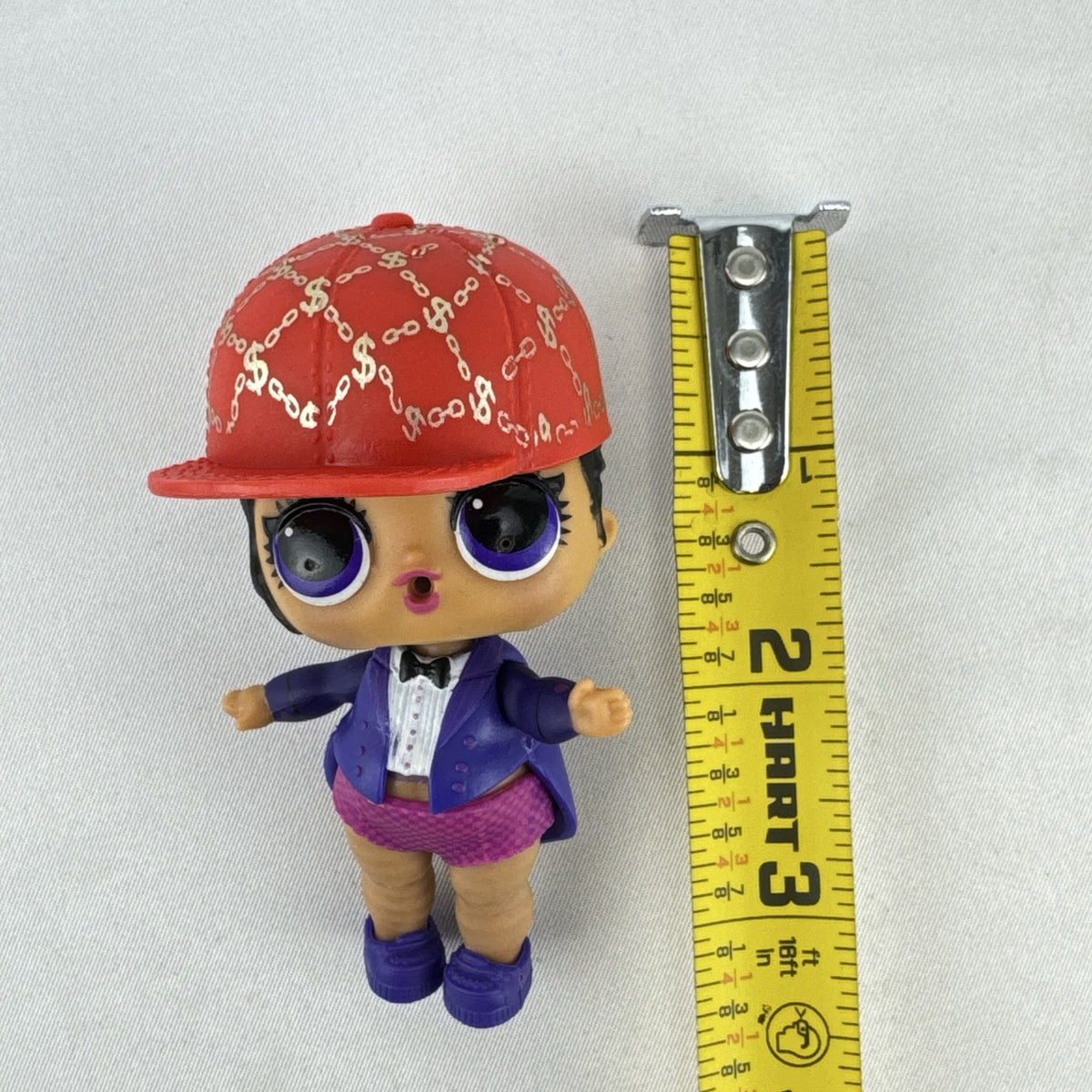MGA Entertainment L.O.L. Surprise! 3-inch vinyl doll wearing a purple tuxedo suit and red cap