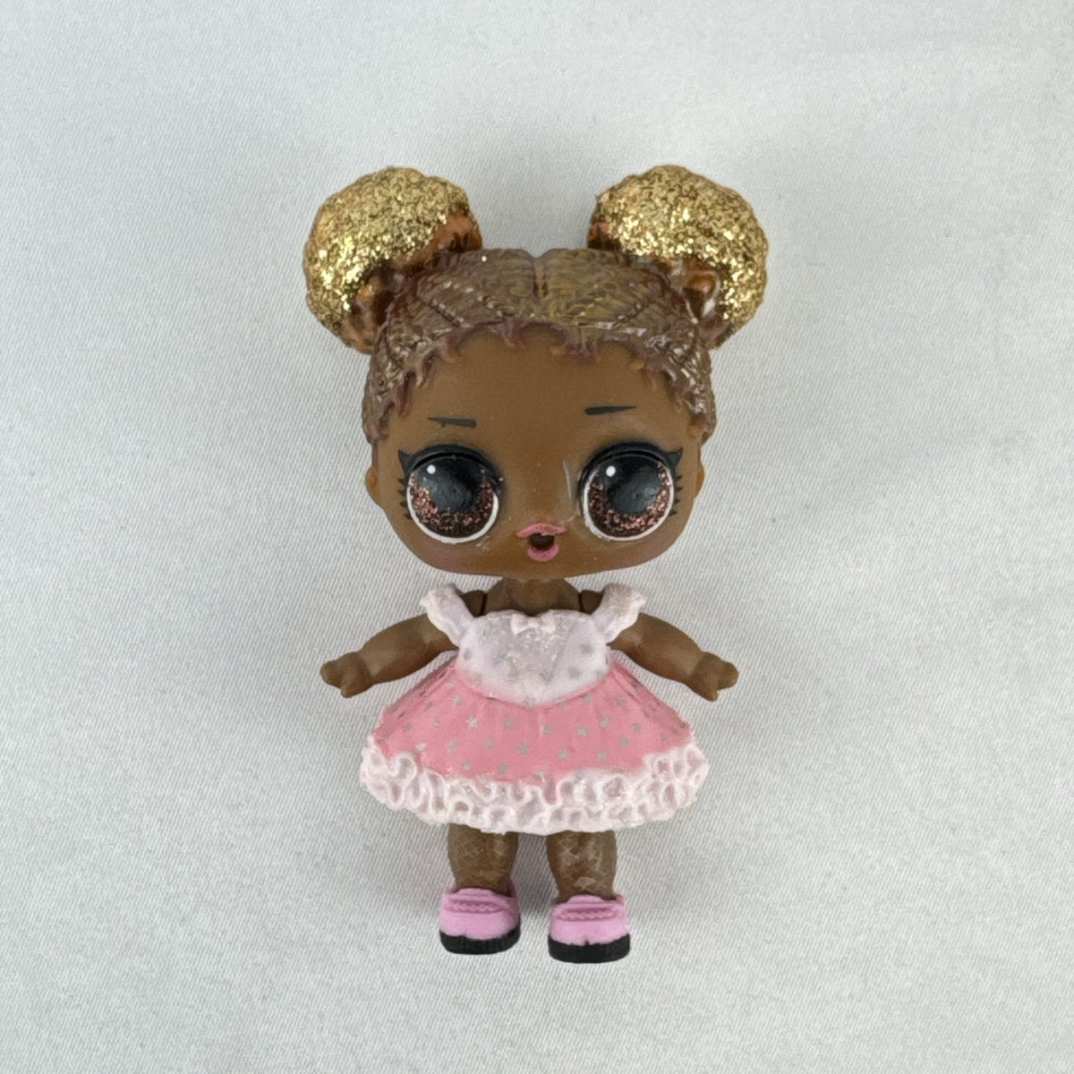 MGA Entertainment L.O.L. Surprise Glitter Series Queen Bee doll with gold glitter hair buns, pink dress, and shoes