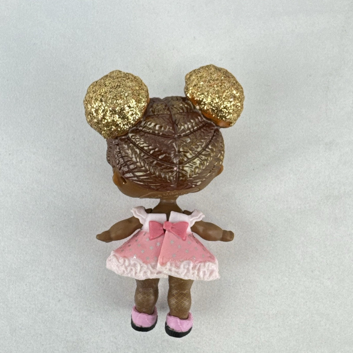 MGA Entertainment L.O.L. Surprise Glitter Series Queen Bee doll with gold glitter hair buns, pink dress, and shoes