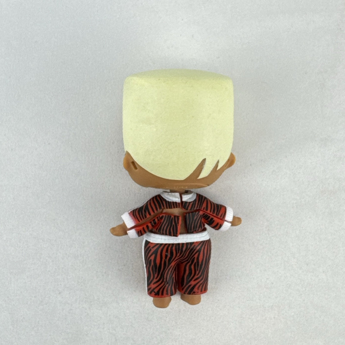 MGA L.O.L. Surprise Boys Swaggy 3-inch mini doll with blonde flocked hair and red tracksuit.