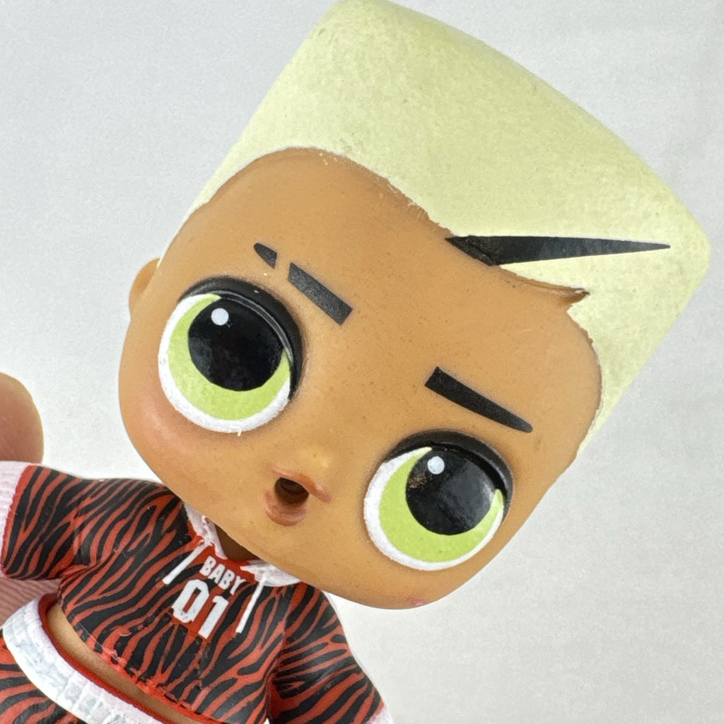 MGA L.O.L. Surprise Boys Swaggy 3-inch mini doll with blonde flocked hair and red tracksuit.