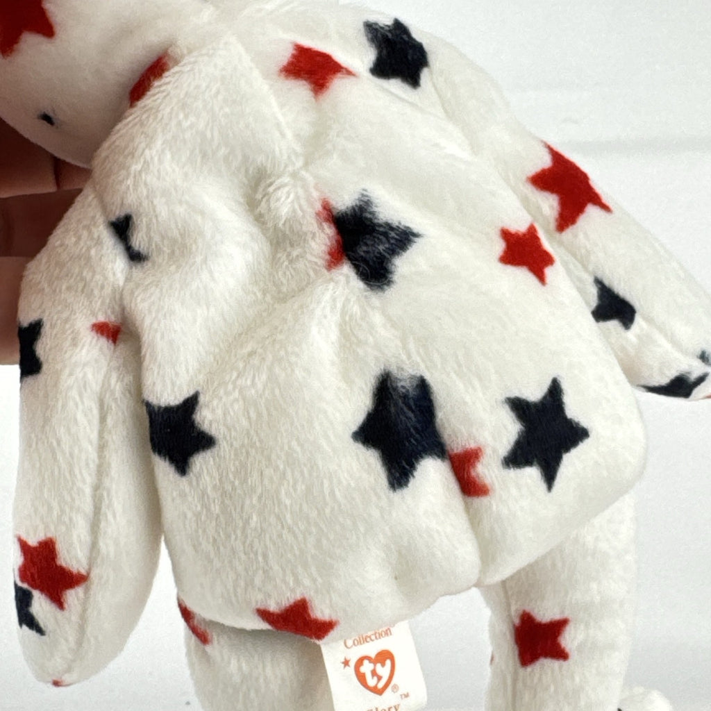 Ty Beanie Baby Glory bear plush featuring patriotic red and navy blue stars and an embroidered American flag