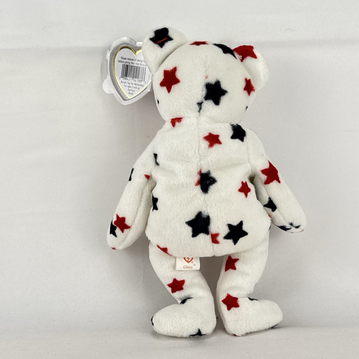Ty Beanie Baby Glory bear plush featuring patriotic red and navy blue stars and an embroidered American flag