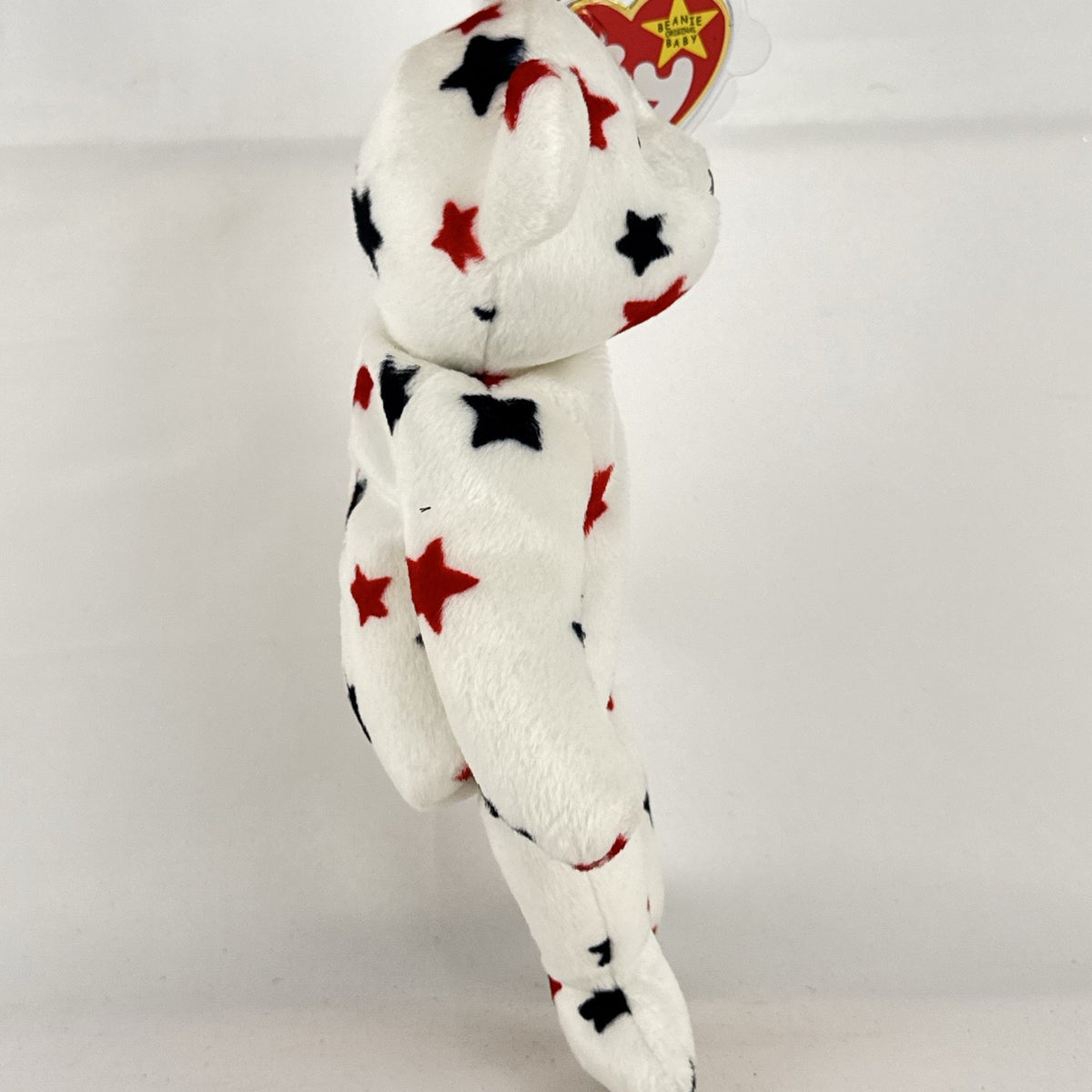 Ty Beanie Baby Glory bear plush featuring patriotic red and navy blue stars and an embroidered American flag