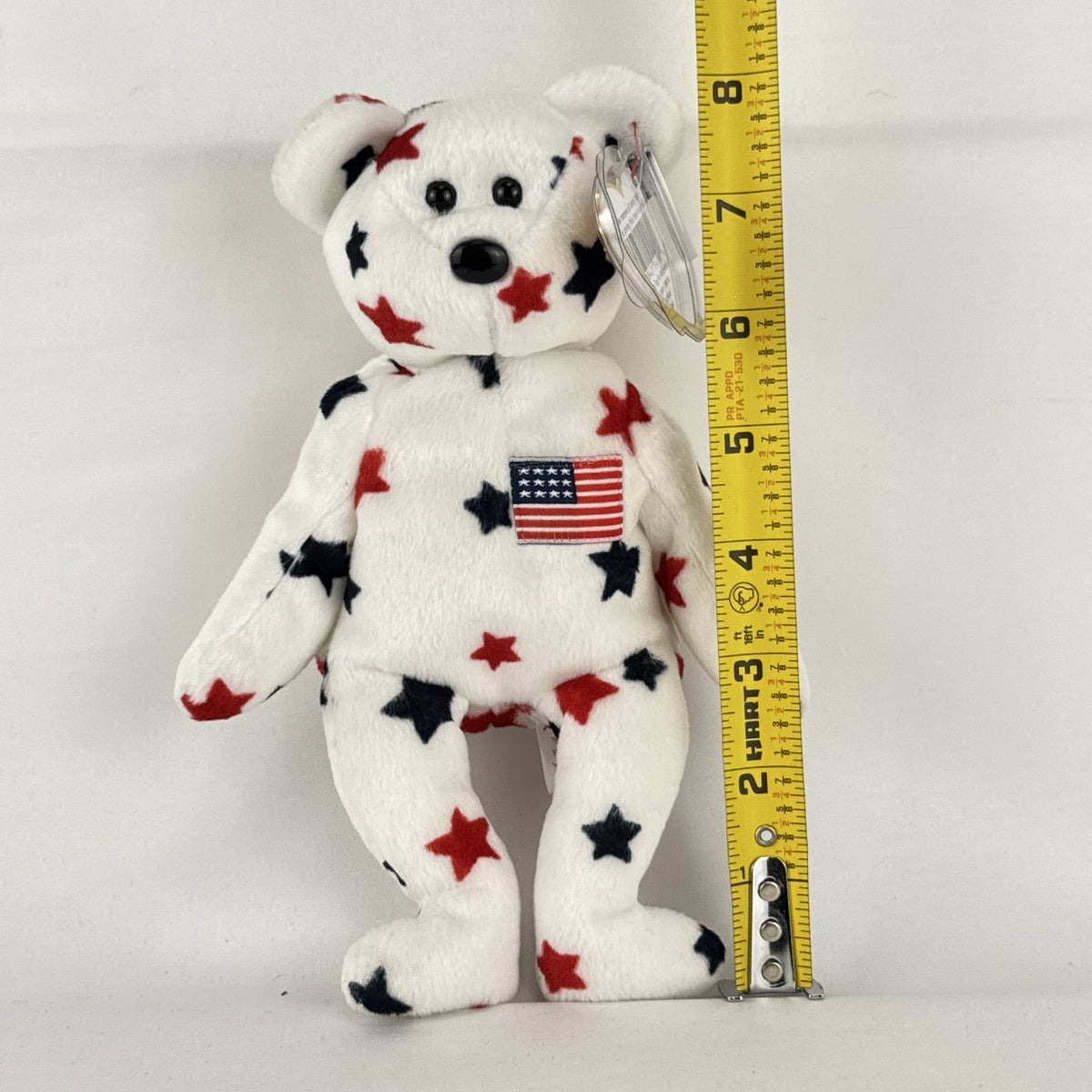 Ty Beanie Baby Glory bear plush featuring patriotic red and navy blue stars and an embroidered American flag