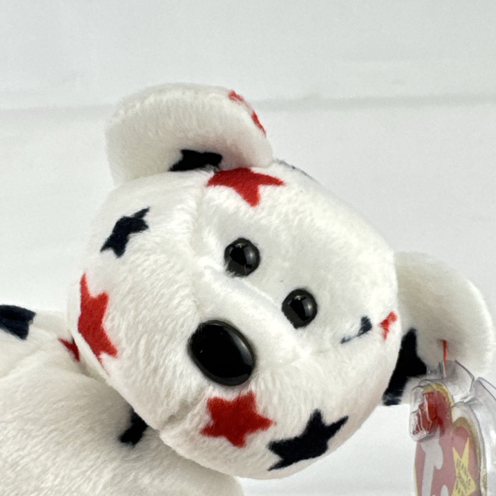 Ty Beanie Baby Glory bear plush featuring patriotic red and navy blue stars and an embroidered American flag