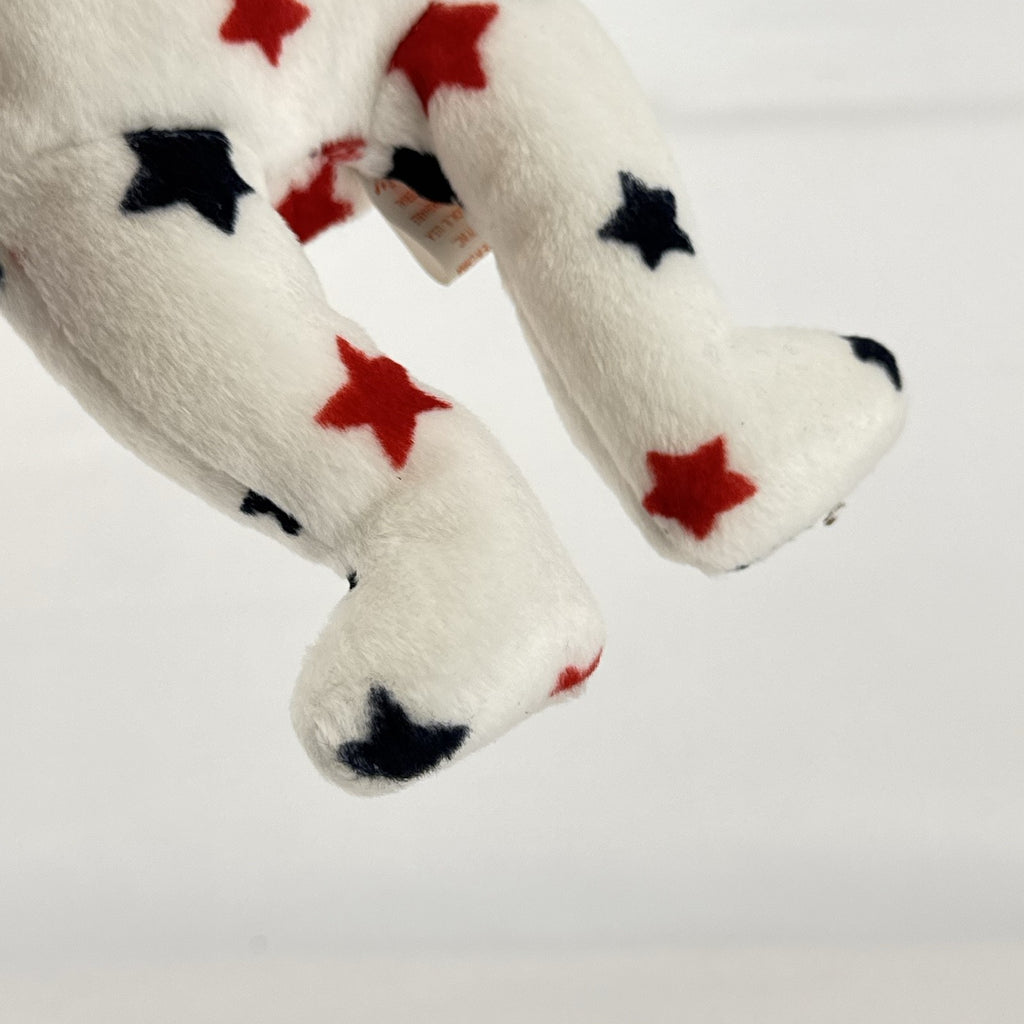 Ty Beanie Baby Glory bear plush featuring patriotic red and navy blue stars and an embroidered American flag