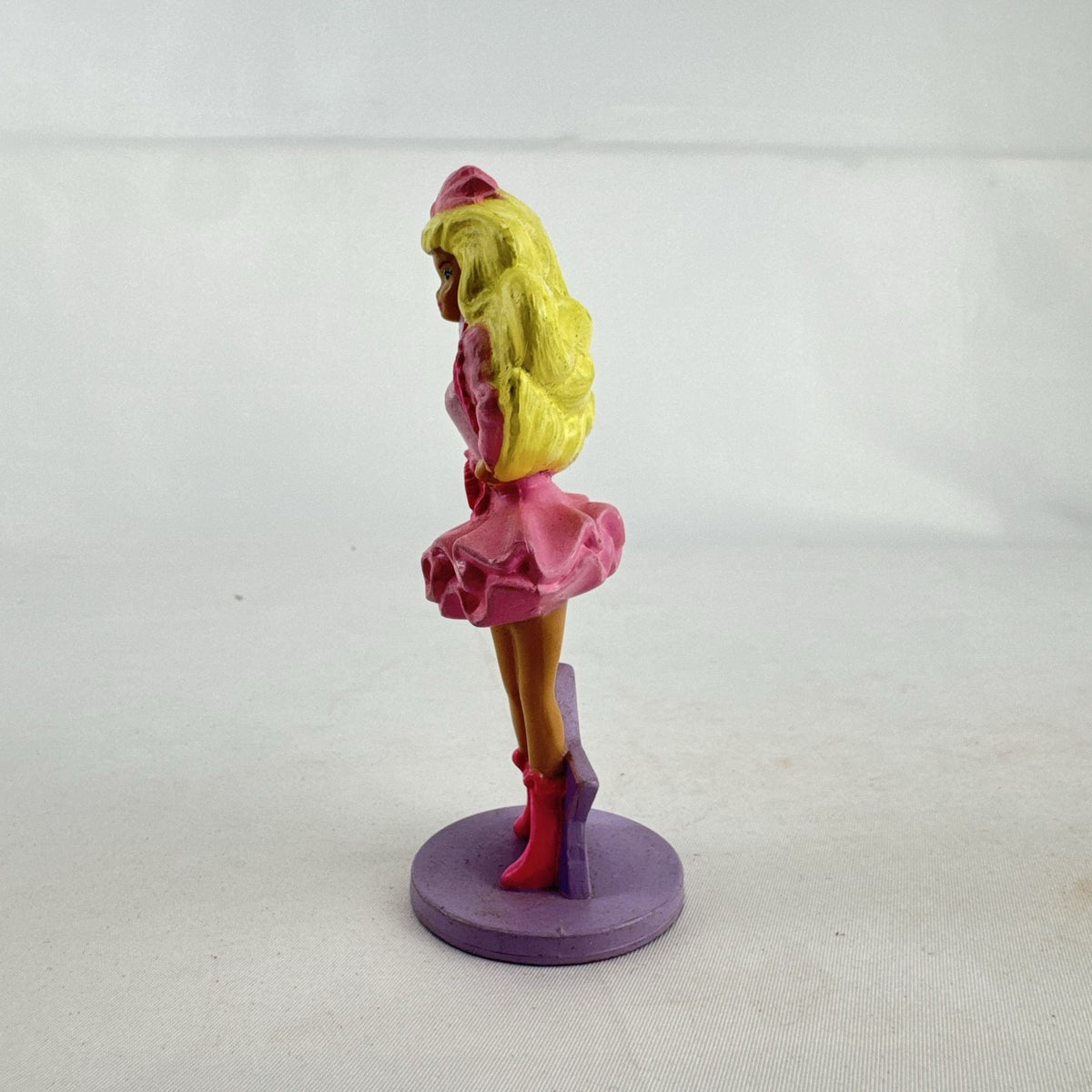 Vintage 1991 Mattel Barbie McDonald's Happy Meal plastic figurine wearing pink dress against a purple star