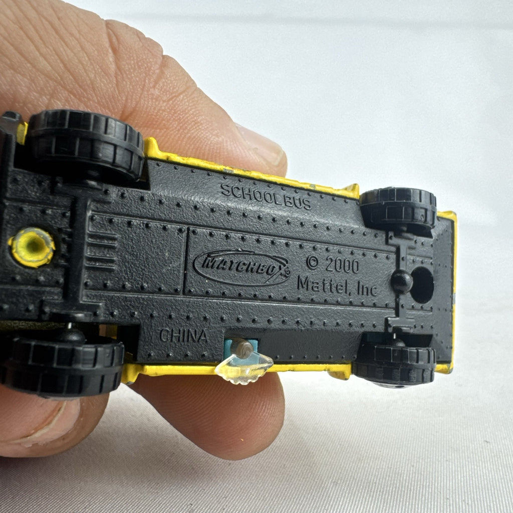 Matchbox 1:64 scale yellow diecast school bus with History dinosaur and rocket graphics