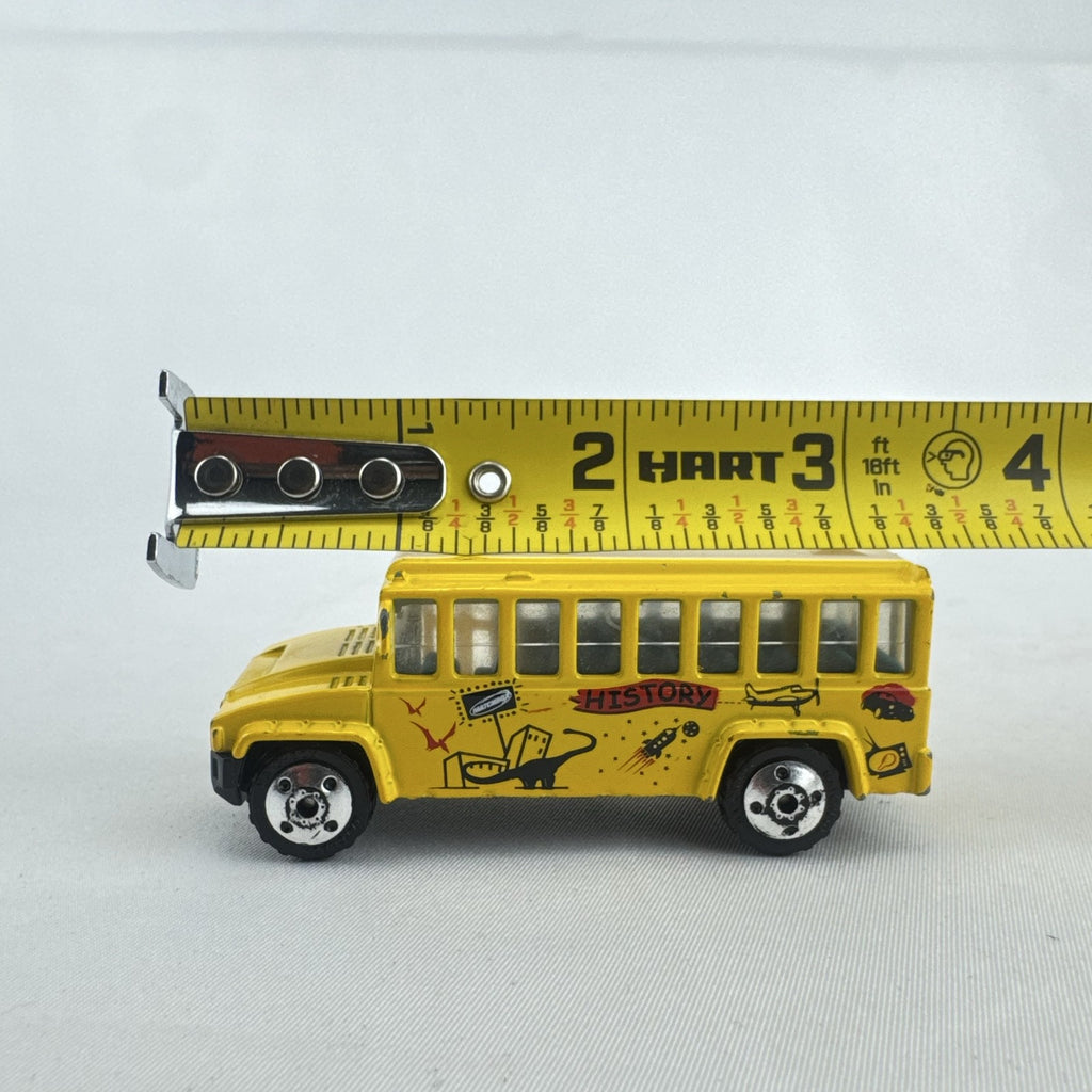Matchbox 1:64 scale yellow diecast school bus with History dinosaur and rocket graphics
