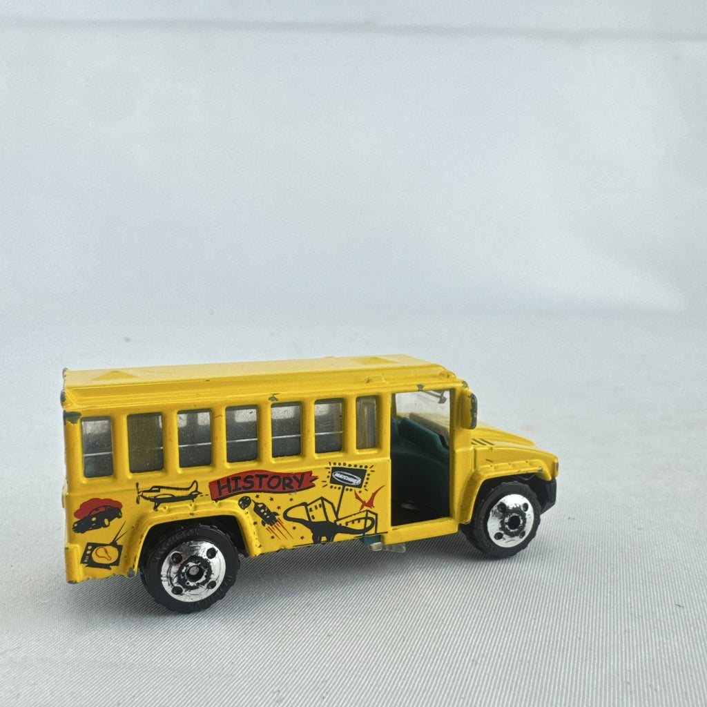 Matchbox 1:64 scale yellow diecast school bus with History dinosaur and rocket graphics
