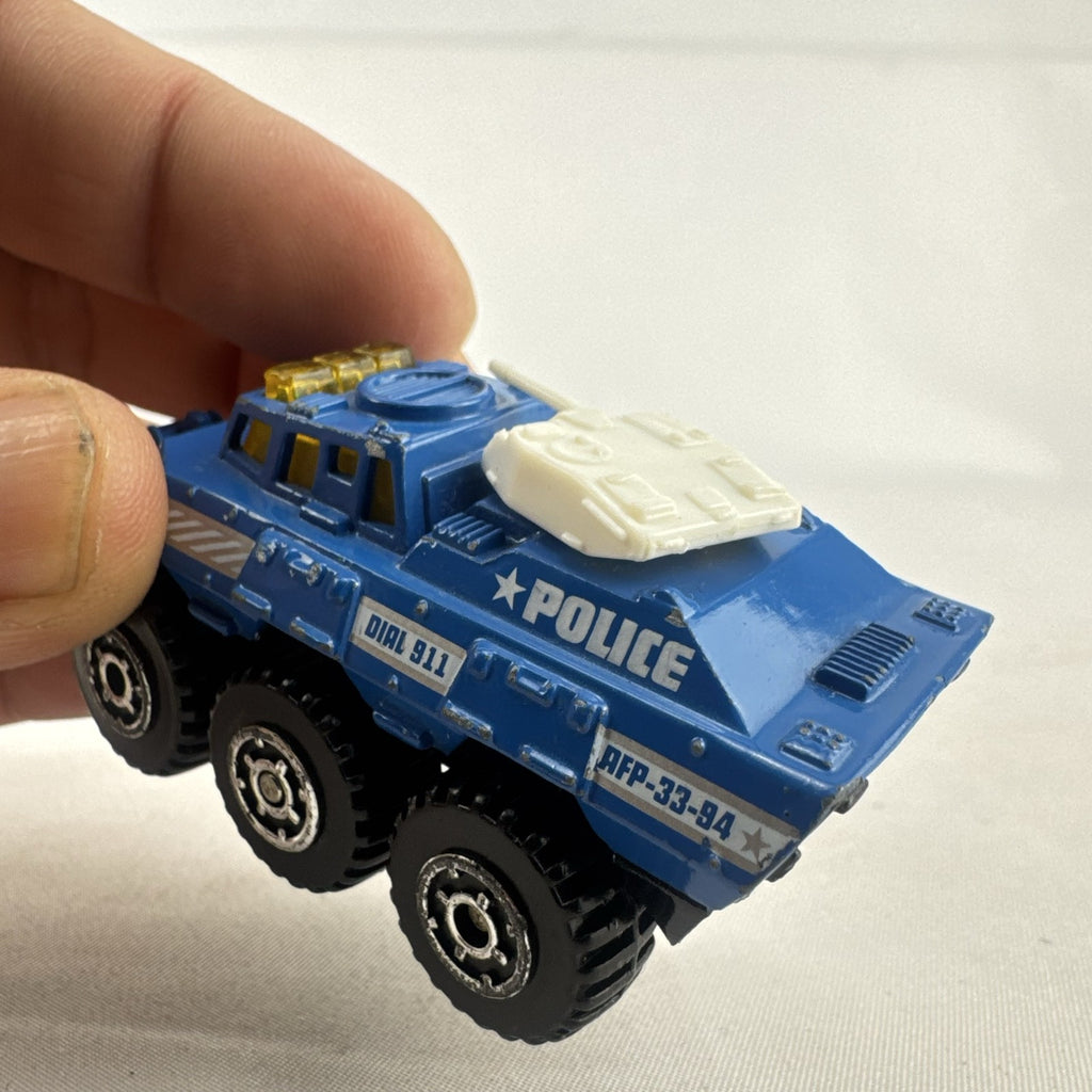 Vintage 1993 Matchbox Battering Ram blue diecast 6x6 police armored truck with rotating turret and front plow.