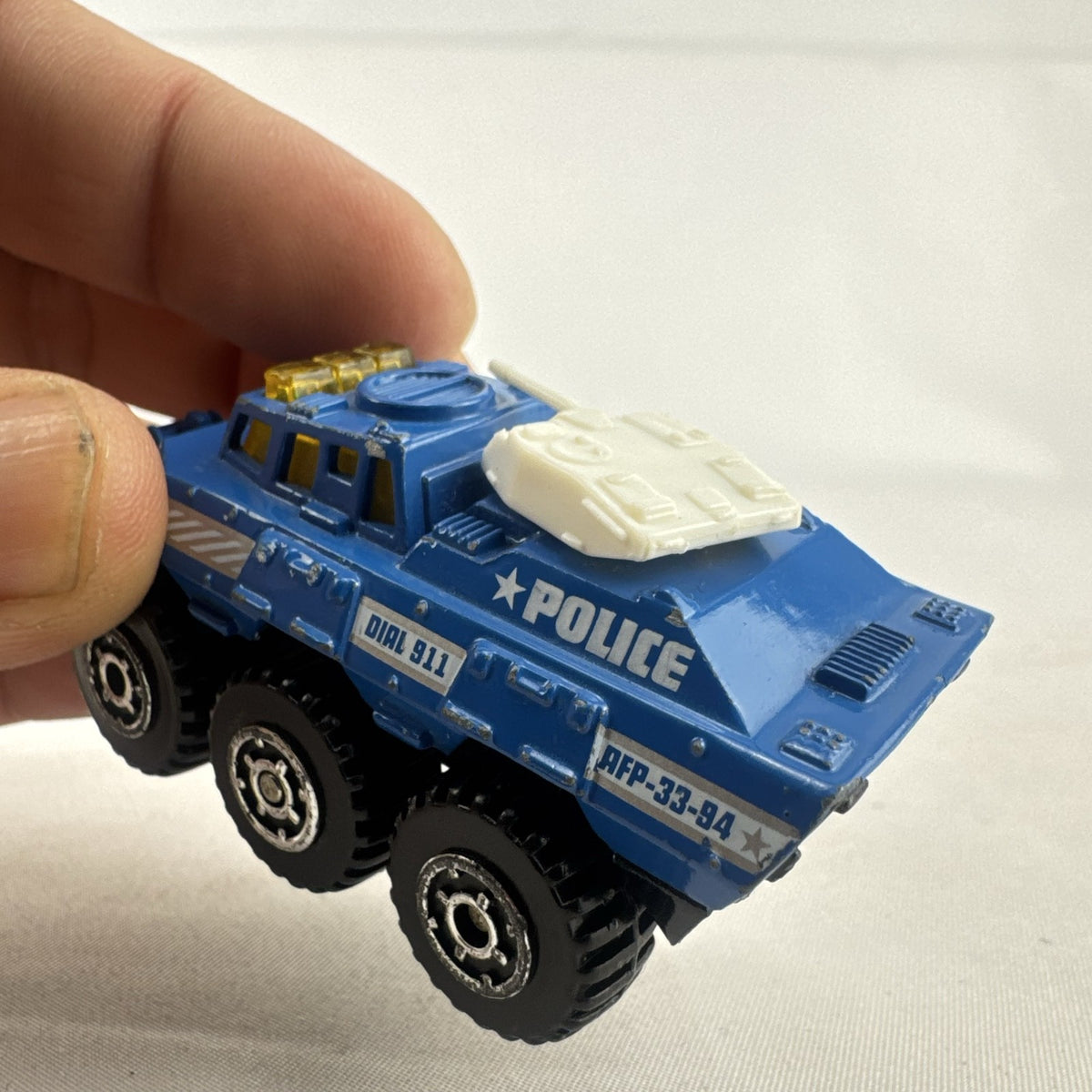 Vintage 1993 Matchbox Battering Ram blue diecast 6x6 police armored truck with rotating turret and front plow.