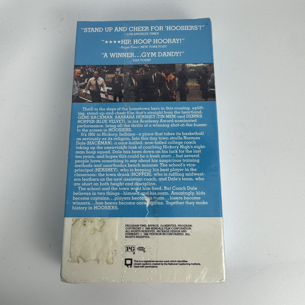 Four factory sealed vintage VHS tapes including Hoosiers, James Bond 007, Sports Illustrated 1993, and Chrysler promo.