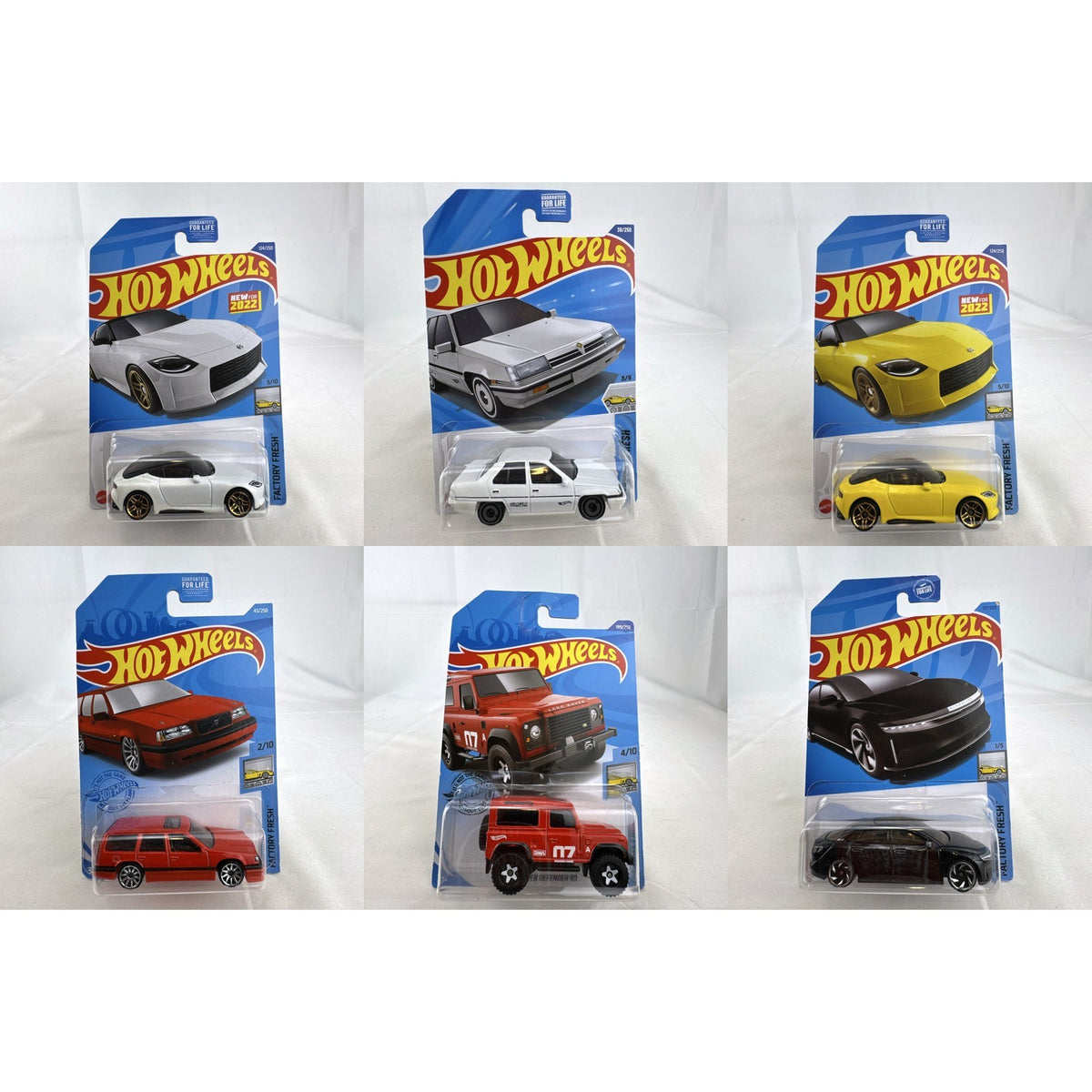 Hot Wheels Factory Fresh 1:64 6-car diecast lot including Nissan Z Proto, Volvo 850 Estate, Land Rover, and Lucid Air.