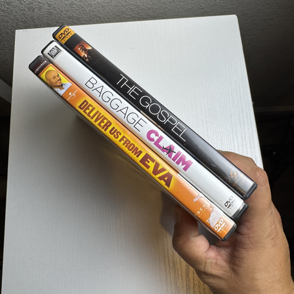 Three DVD cases featuring Baggage Claim, Deliver Us From Eva, and The Gospel romantic drama films.
