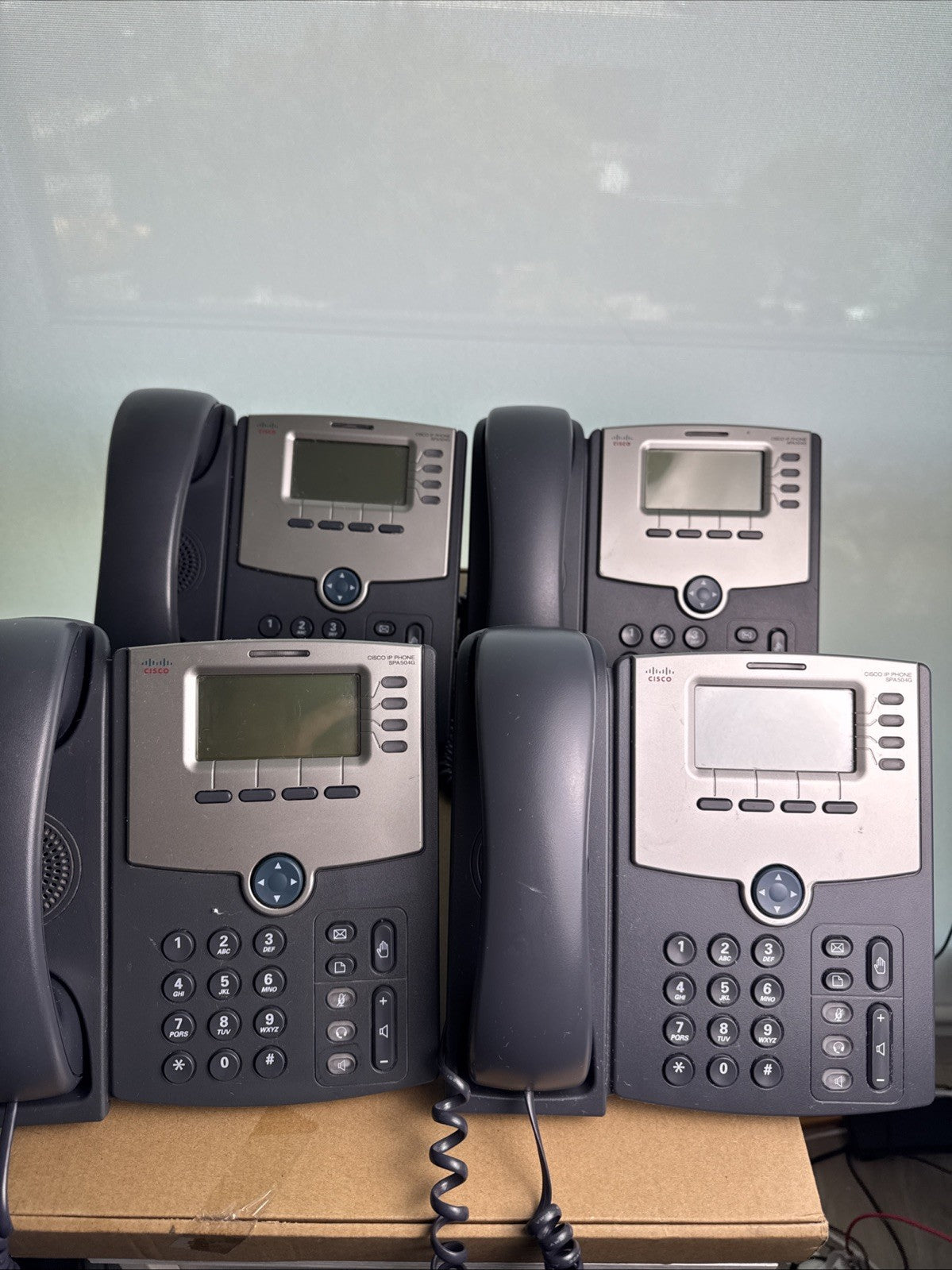 Lot of 4 unlocked Cisco SPA504G 4-line IP phones with handsets and desktop stands